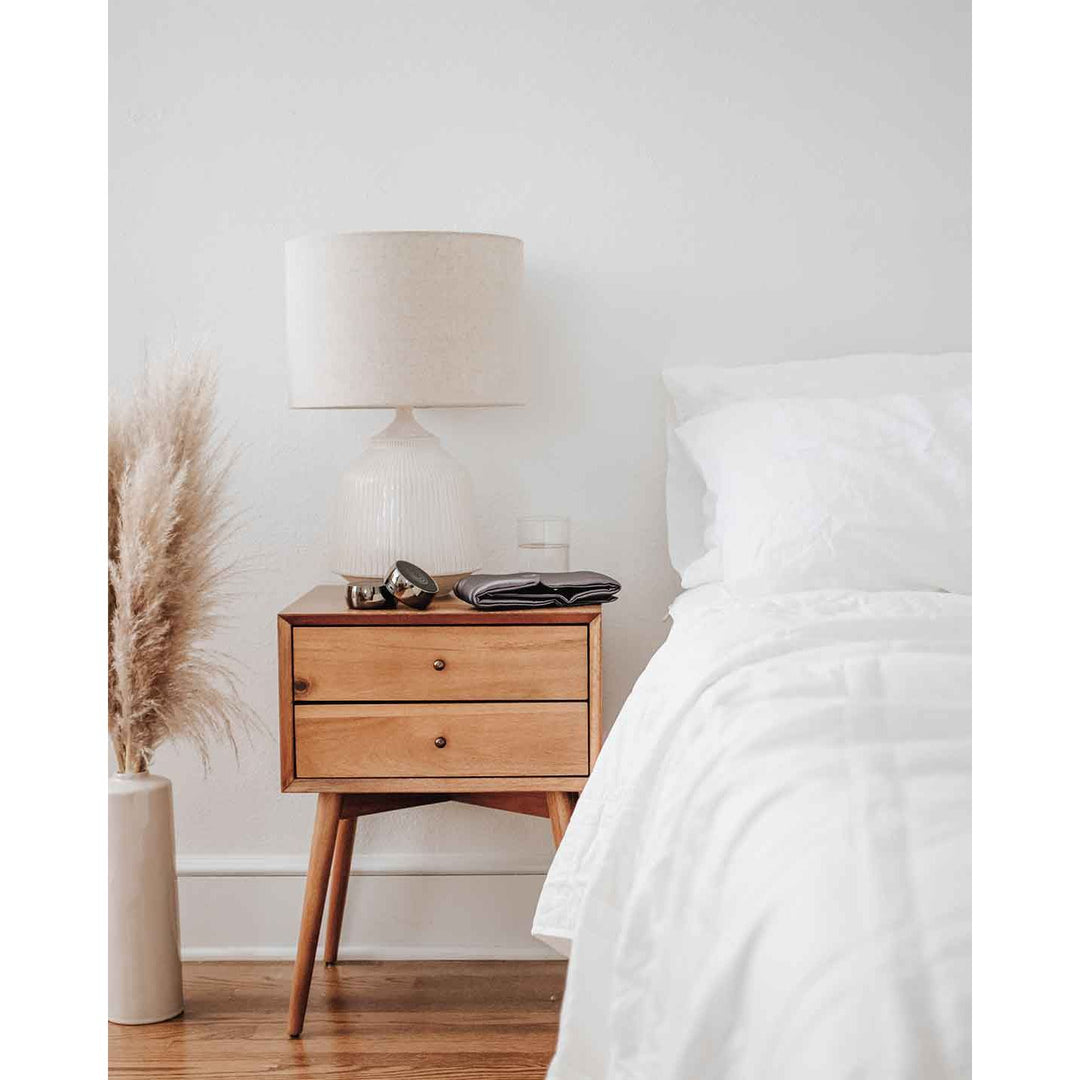 A set of two meditation speakers sit on bedside table 