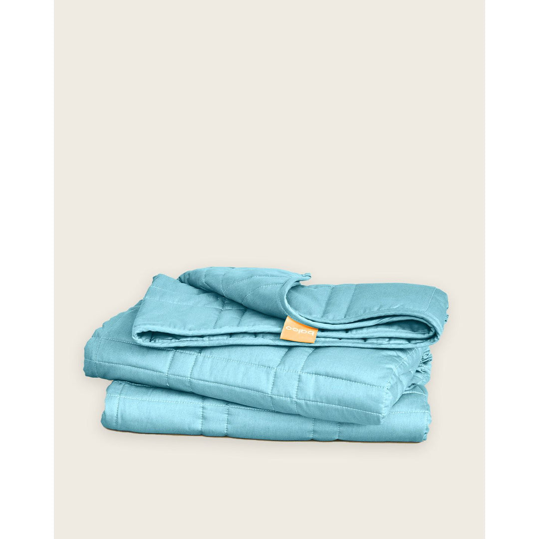 The aqua weighted blanket by baloo folded on a blank background [44385363689691]