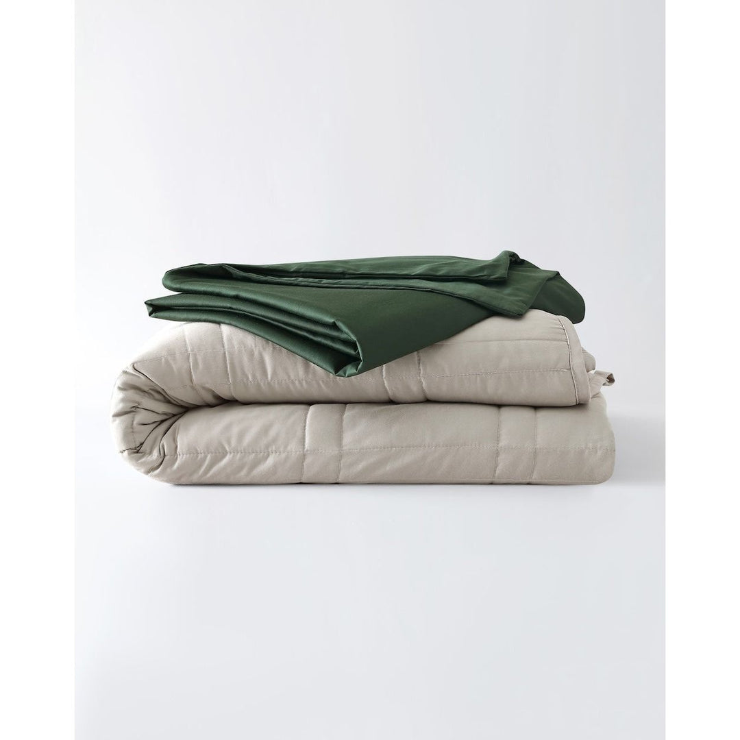 A silver sage weighted throw with a spruce green cotton duvet cover folded on top. [460619214030-9, 4630120510281-1]