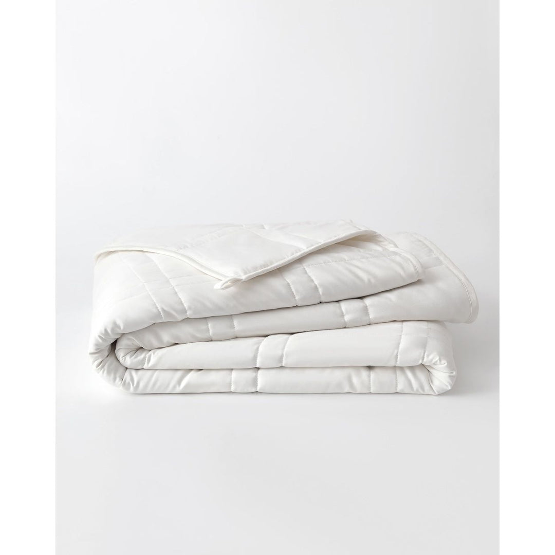 A white cotton weighted blanket is folded on a plain background.  [42934587621595,42934587818203, 42934587850971, 42934587883739,46063268298971, 46063268331739, 46063268364507, 46063268397275, 46063269150939]