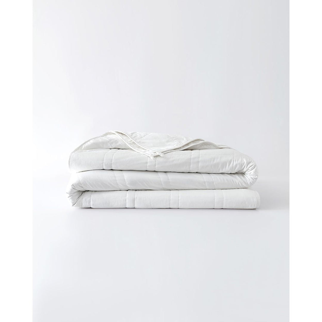 Folded white cotton comforter. [32783560769616, 32783560802384, 32783560933456]