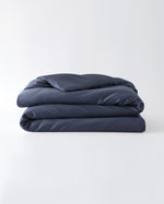 Load image into Gallery viewer, A folded cotton duvet cover in Luna Blue on a blank background [44422682083547, 45027100033243, 46061921763547, 46301205332187, 46063268331739, 46301204938971, 46061921632475, 46061921501403, 46301205201115, 46061921370331, 46301205070043, 46730786668763, 46730786930907, 46730787193051, 46730787455195]
