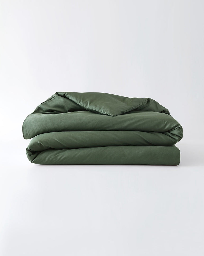 A folded cotton duvet cover in spruce against a plain background [44422682116315, 46063268364507, 46301204971739, 46061921796315, 46301205364955, 46061921665243, 46061921534171, 46301205233883, 46061921403099, 46301205102811, 46730786701531, 46730786963675, 46730787225819, 46730787487963]