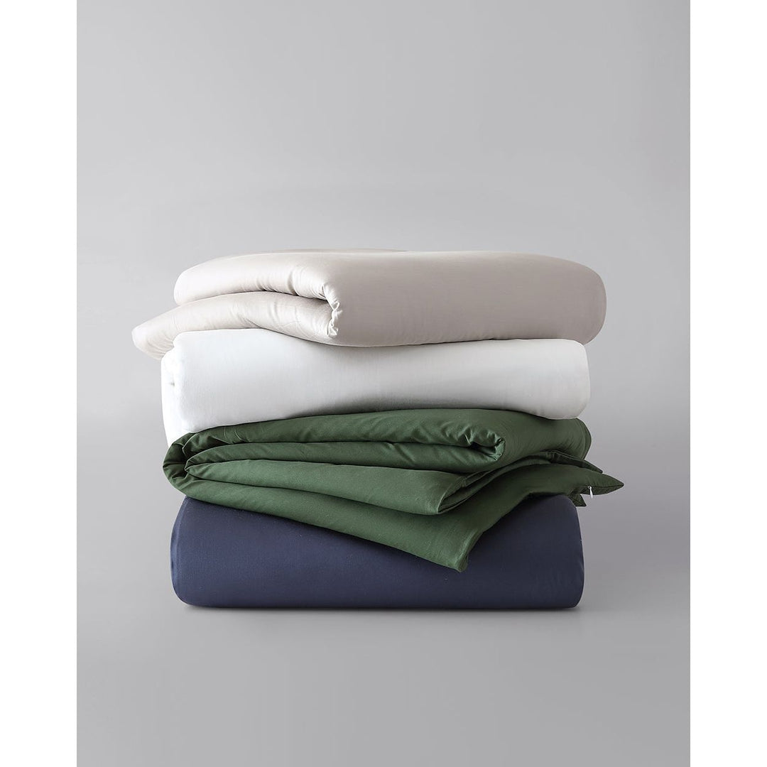 A stack of cotton duvet covers against a plain background {44422681886939,44422682050779,44422682083547,44422682116315,44422682149083,45027099410651,45027099771099,45027100033243]