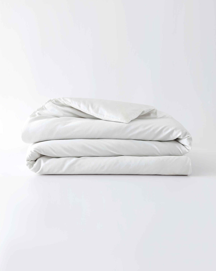 A white cotton duvet cover folded against an empty background [44422681886939,45027099410651,46063267610843,46063267643611,46063267676379,46063267709147,4606326839727546730800627931, 46730800759003, 46730800890075, 46730801021147]
