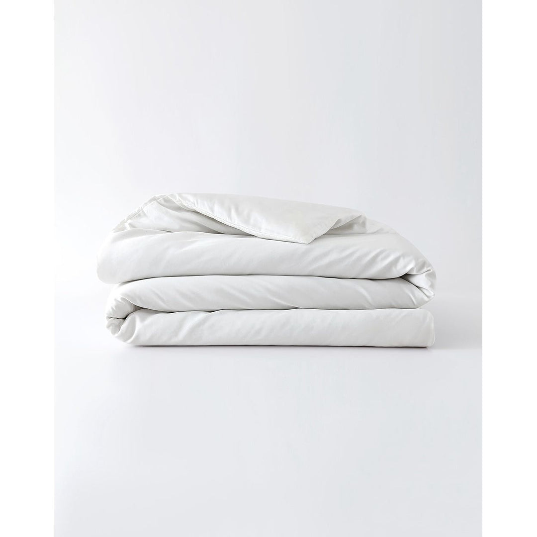 A white cotton duvet cover folded against an empty background [44422681886939,45027099410651,46063267610843,46063267643611,46063267676379,46063267709147,46063268397275]