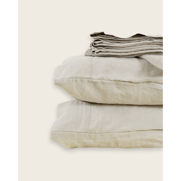 A stack of linen sheets including 2 pillows against a plain background. [39418737721528, 39418737754296, 39418737787064, 45933265289435].