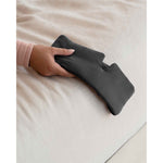 Load image into Gallery viewer, A woman's hand holds a grey silk sleep mask over the side edge of a bed [44377020793051]
