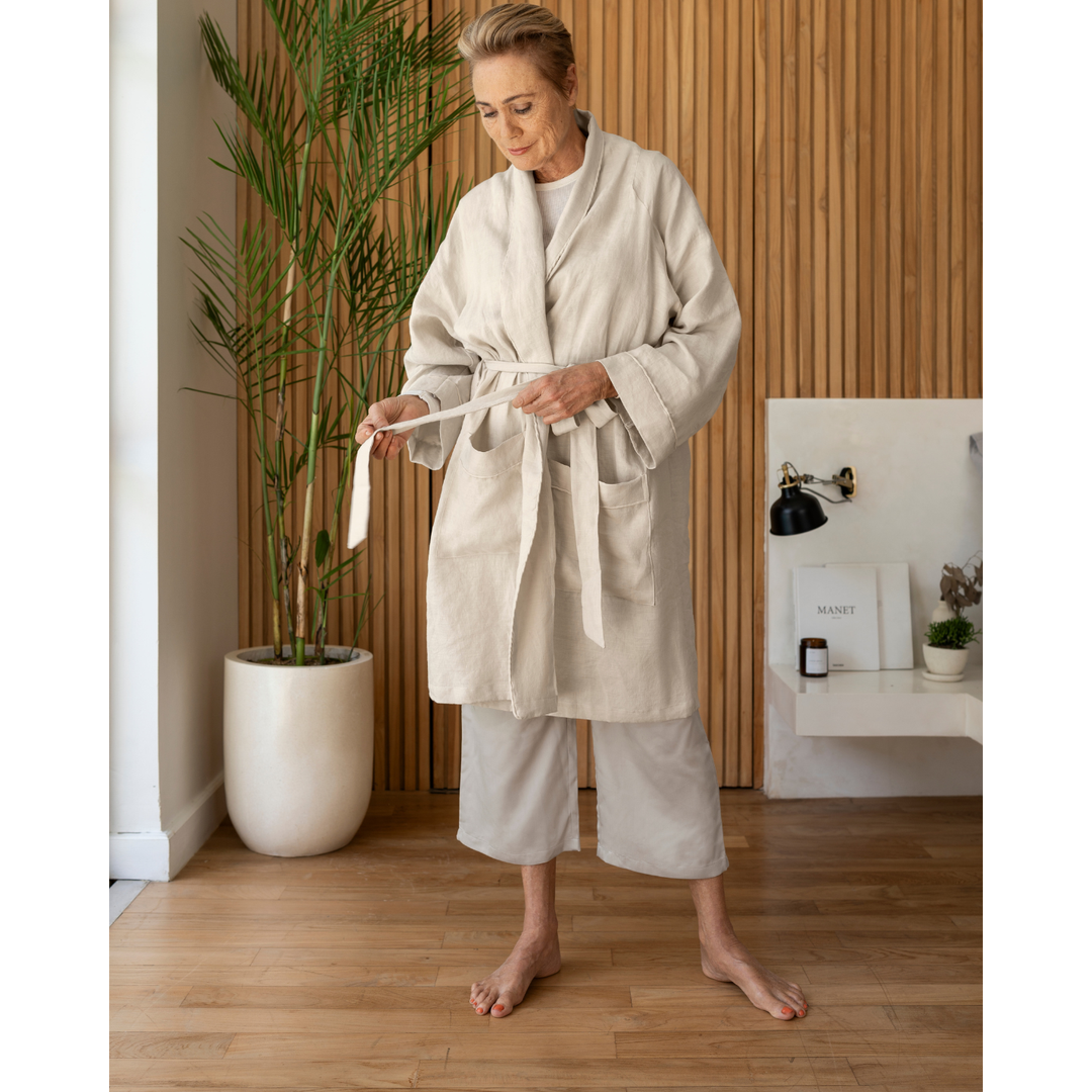 Woman tying oatmeal linen robe [45949480796379, 45949488070875]